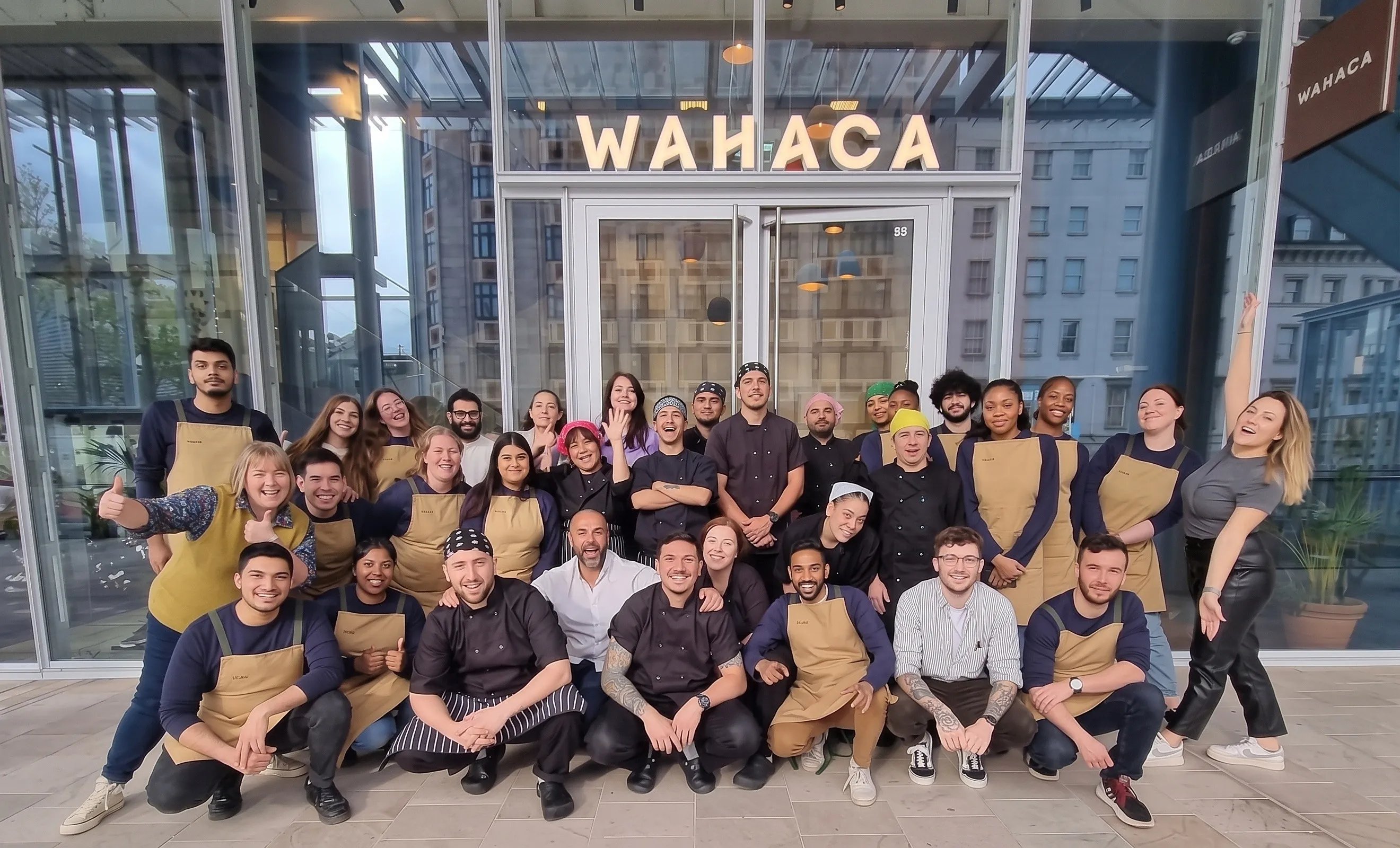 Wahaca restaurant team in branded aprons outside the restaurant